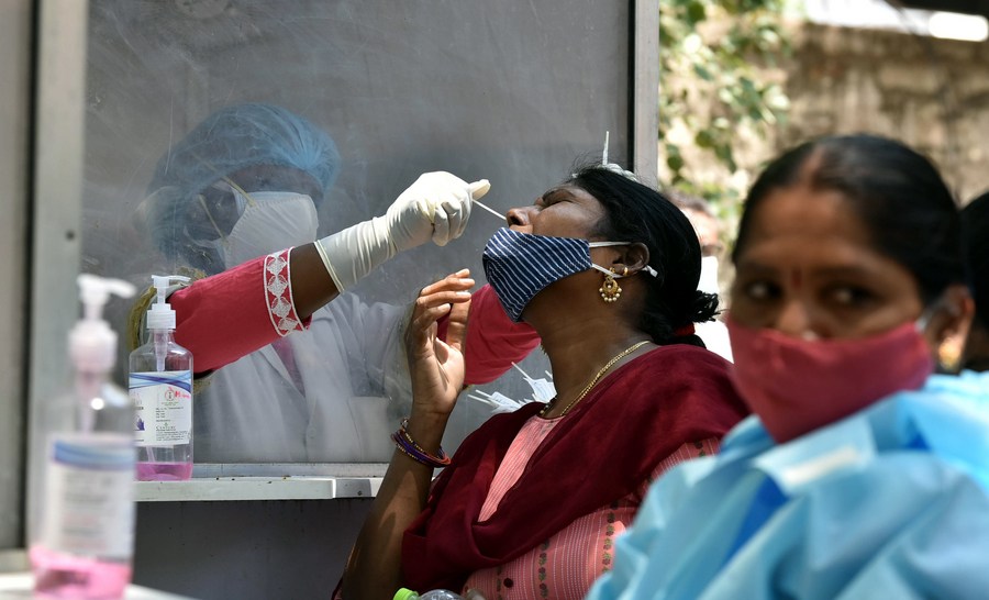 A health worker collects nasal swab from a woman for COVID-19 test in Hyderabad, India, on May 9, 2021. (Str/Xinhua) XxjhmeE007030 20210513 CBMFN0A002