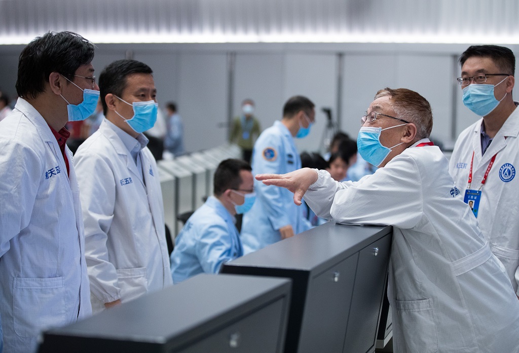 Ye Peijian (2nd R), academician of the Chinese Academy of Sciences, talks with space engineers after Zhurong drives down to the Martian surface at the Beijing Aerospace Control Center on May 22, 2021. (Xinhua/Jin Liwang) XxjwshE007088 20210522 CBMFN0A003